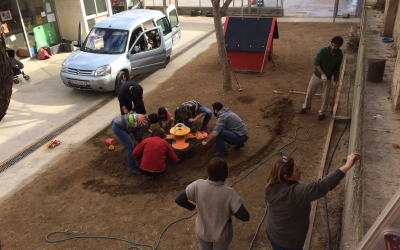 Pares, mares i mestres de l'Escola Nostra Llar treballant en el pati | Cedida